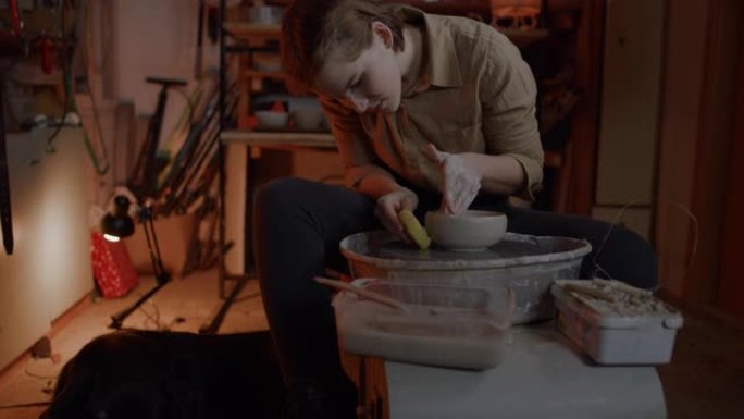 SLO MO在她的陶器工作室工作的女陶工的肖像照片