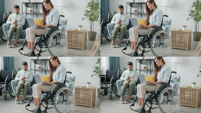 残疾夫妇男女使用现代设备笔记本电脑和智能手机在家在线工作