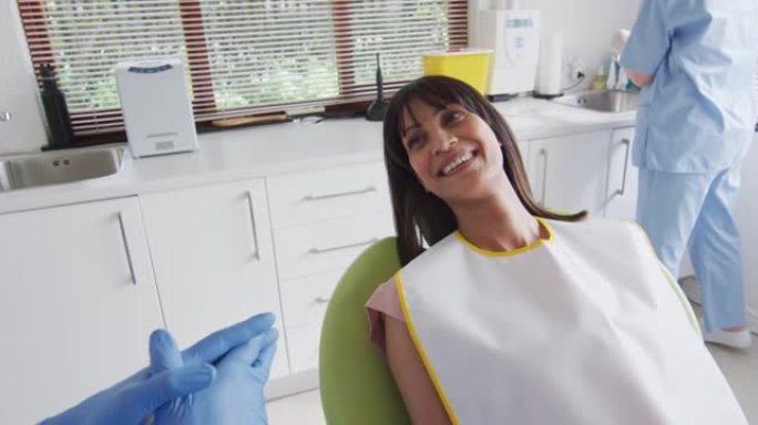 高加索男性牙医在现代牙科诊所为微笑的女性病人做准备