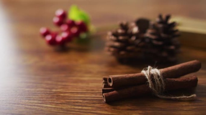 木制背景上有松果、肉桂和红色浆果的圣诞装饰品视频