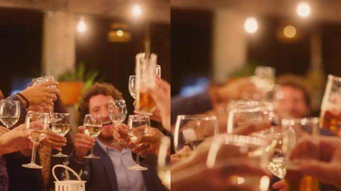 垂直屏幕: 大型晚宴，一小群朋友在餐厅庆祝。美丽快乐的主人在晚上坐在桌子旁敬酒并举起酒杯。