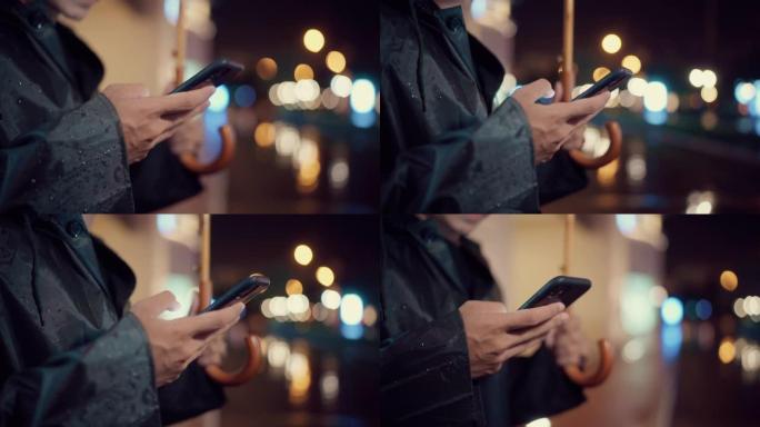 年轻的亚洲男子深夜乘出租车或优步。在寒冷的雨夜里，他在街上撑着雨伞。