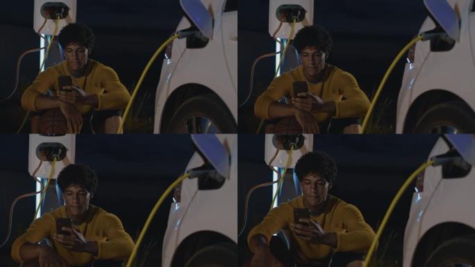 SLO MO年轻的篮球运动员晚上在停车场用智能手机充电时使用智能手机