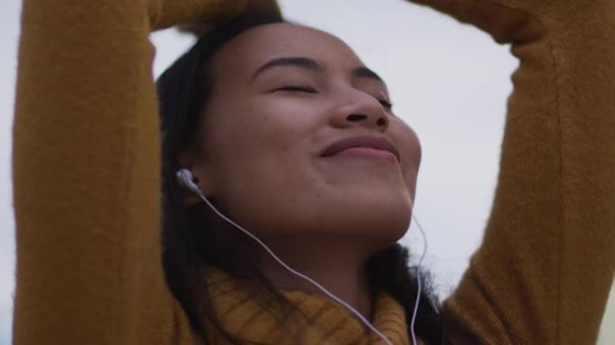 亚洲女子戴耳机听音乐微笑