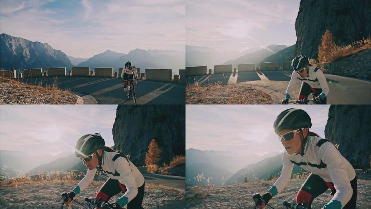 坚定的女自行车手在阳光明媚的山脉上坡骑自行车