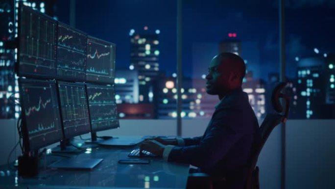 股市日交易者在计算机上工作，带有实时投资图表的多显示器工作站。成功的非洲裔美国商人为赢得交易而挥拳。