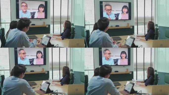 亚洲白领与公司员工进行视频会议在会议室讨论董事会与外国投资者进行视频通话。并购业务会议