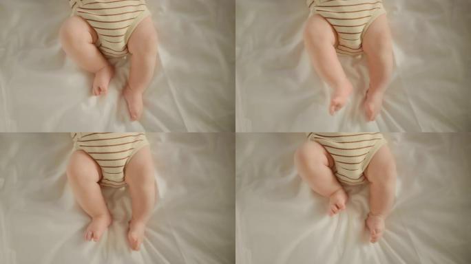 真实的特写镜头，一个可爱的新生婴儿躺在婴儿床的背上。高加索新生儿蹒跚学步的小脚是焦点。童年、新生活和