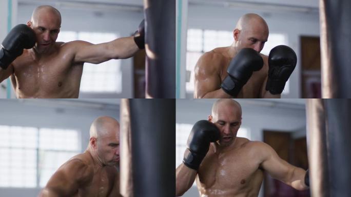 高加索男教练戴着拳击手套在健身房用出气筒训练