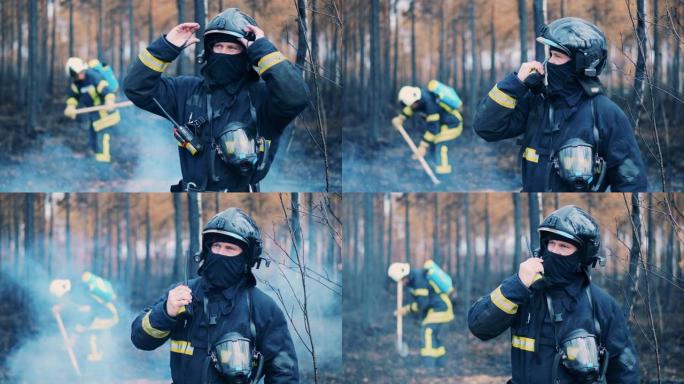 消防员正在充满烟雾的森林里通过收音机讲话