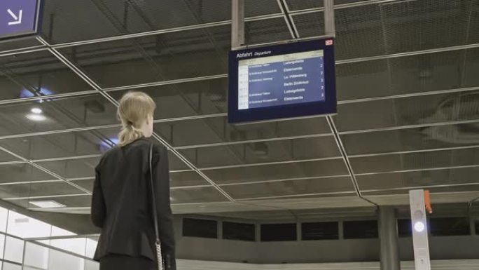 柏林火车站的女商人检查时间表