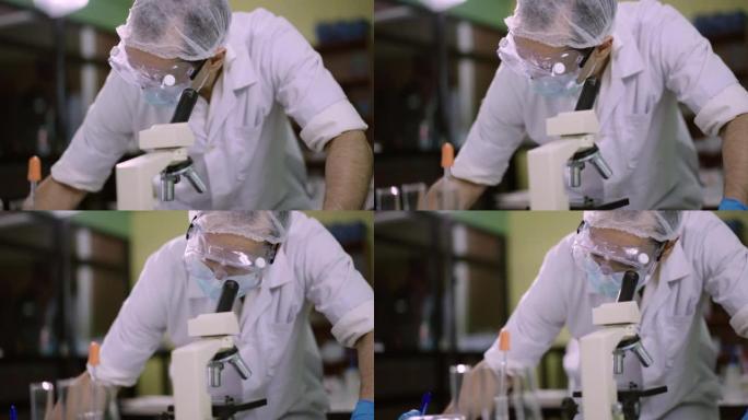 科学家使用显微镜并在实验室中与病毒进行笔记实验