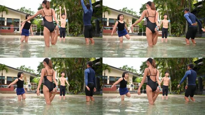 亚洲华裔游泳教练为幼儿做热身运动