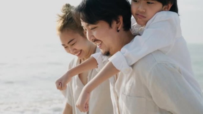 亚洲家庭与他们的儿子在海滩上度过愉快的一天