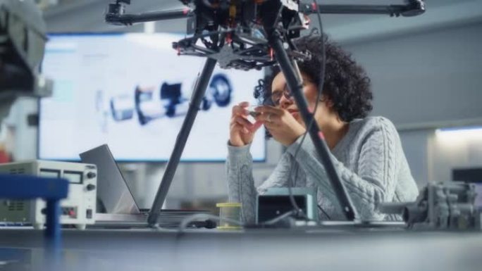 集中的女性黑人工程师在研究中心实验室开发无人机时编写代码。无人机设计理念的突破。肖像视图