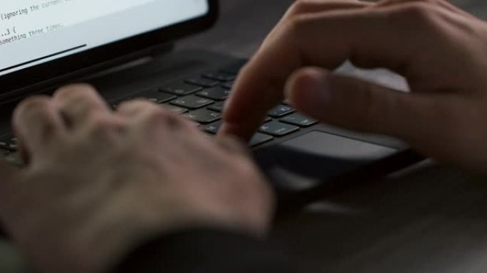 一只人手在黑色笔记本电脑键盘上慢动作近距离打字