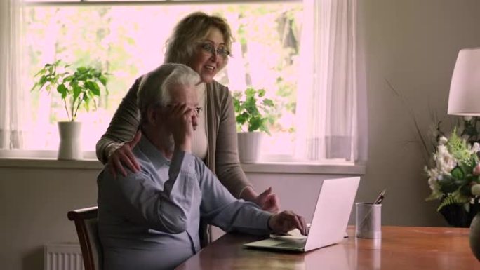 老年配偶使用笔记本电脑阅读好消息庆祝彩票中奖
