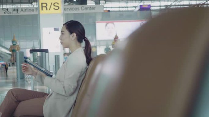 亚洲旅行商务女性在机场等待飞机。