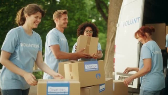 由年轻志愿者组成的快乐团队准备人道主义援助和捐款，在户外的货车中装载纸板箱。慈善工作者在人道主义捐赠