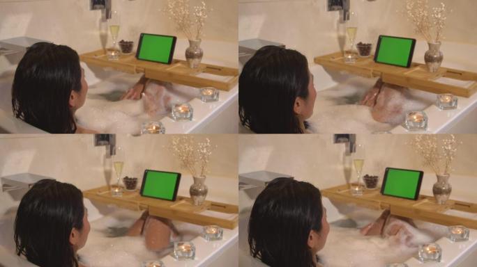 女士坐在泡泡浴中，通过在线视频通话聊天