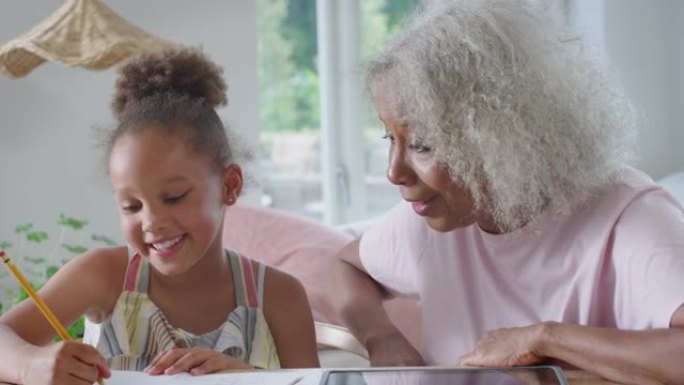 祖母用数字平板电脑帮助孙女在家上学