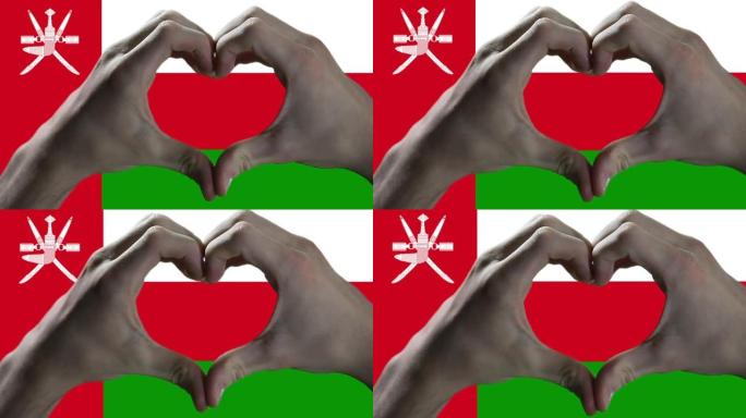 双手在阿曼国旗上显示心脏标志。