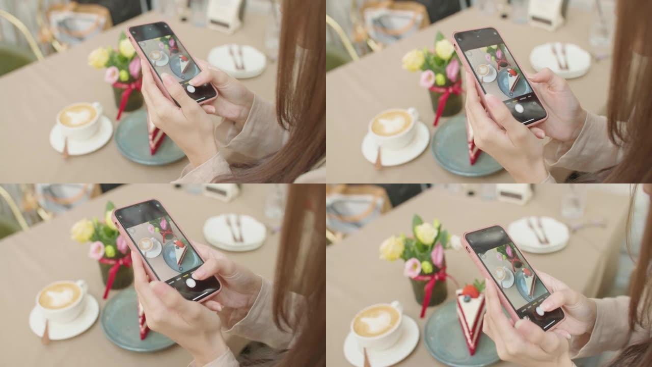 特写女人拿着智能手机在咖啡店里拍照。