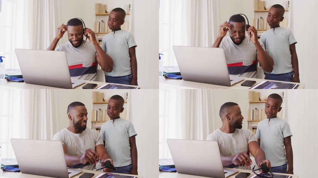 非裔美国父亲在笔记本电脑上完成视频聊天，并在ho工作时与儿子交谈