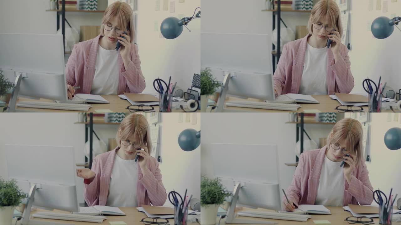 年轻女商人独自在办公室工作的手机上讲话的肖像