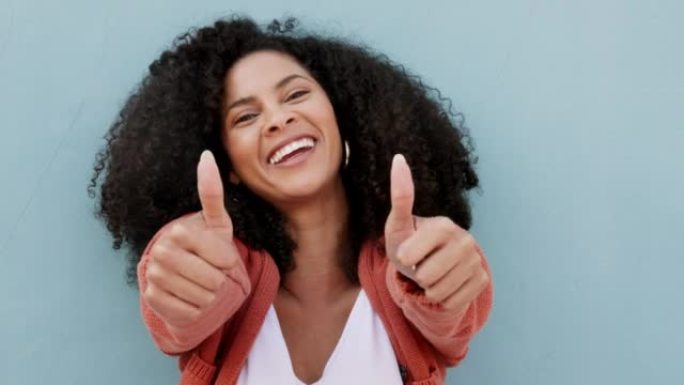 竖起大拇指，微笑和快乐的黑人妇女站在蓝色工作室背景模型上。双手，如手势或认可，满意或好，鼓励或欢迎，