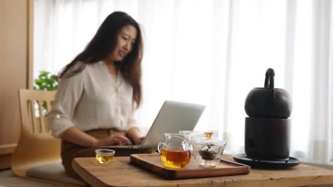 在茶室的笔记本电脑上工作的亚洲女性