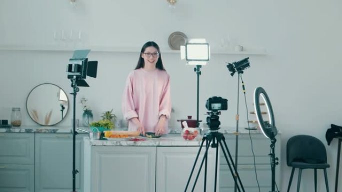 开朗的女士正在烹饪视频中拍摄