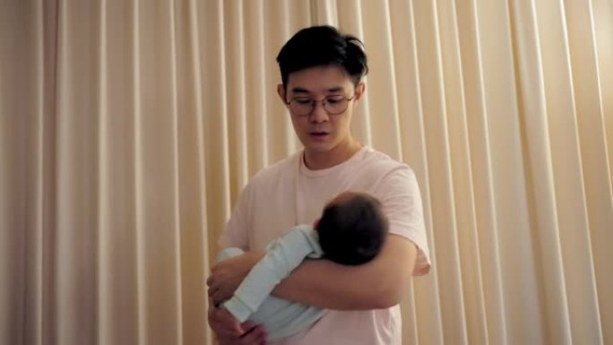 父亲怀里抱着可爱的新生婴儿。他试图让婴儿晚上睡觉。为人父母，父亲的概念