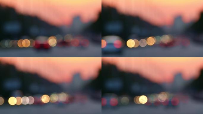 模糊的城市交通。日落城背景下的散焦车灯。汽车在高峰时间通过高速公路。美国洛杉矶
