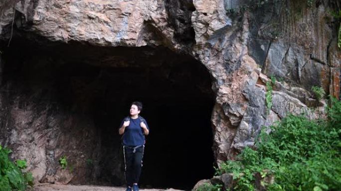 一名亚洲中国中年女性旅行徒步旅行，探索马来西亚怡保霹雳州洞穴森林，背包