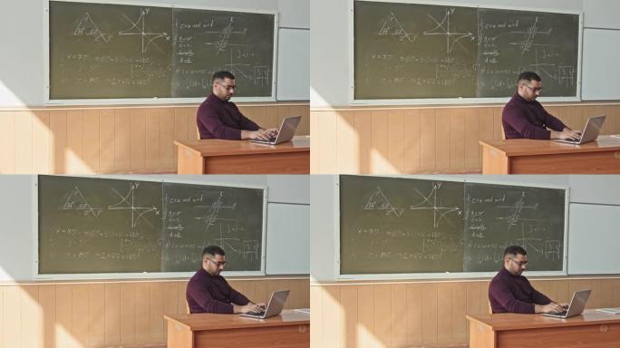 在教室里使用笔记本电脑的成年数学老师