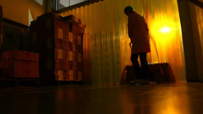 男性工人在纸箱工厂中数产品，使用轮廓技术拍摄以显示工人的轮廓。