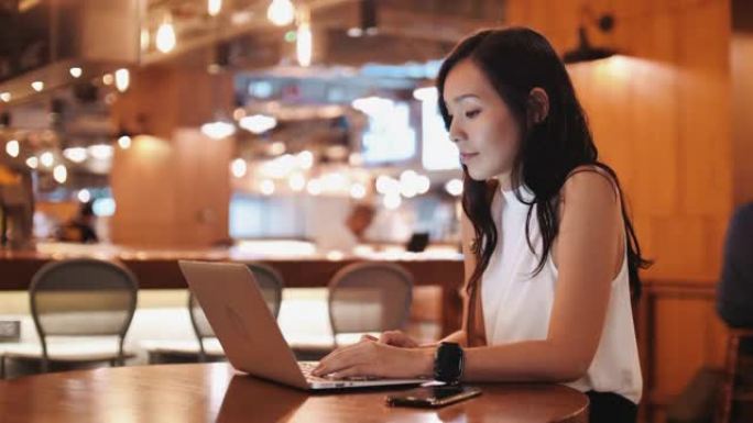 亚洲女商人在咖啡店使用笔记本电脑