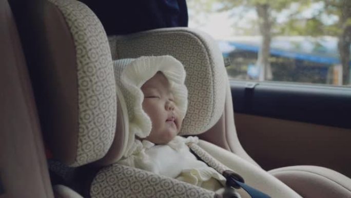公路旅行时坐在汽车座椅上的小婴儿。