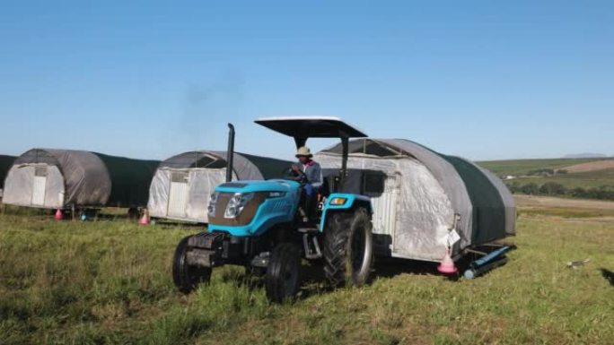 特写。非洲黑人农民用拖拉机移动自由放养的有机便携式可移动鸡舍