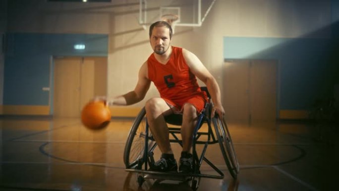 帅气的轮椅篮球运动员的肖像穿着红色的衬衫运球，看着相机，完美地射击。坚定的残疾人将获胜并成为冠军