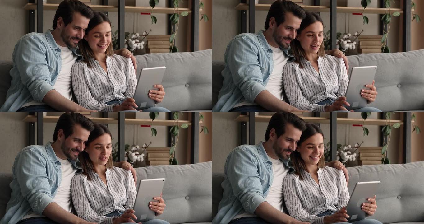 使用电脑平板电脑连接微笑真诚的家庭夫妇。