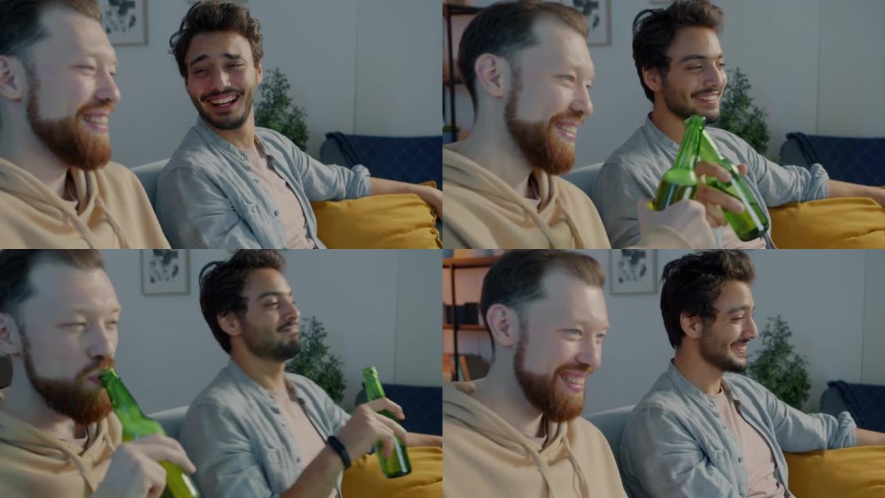 高加索人和中东男人晚上在公寓里笑着喝啤酒看电视