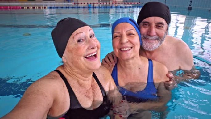 一群老年人在室内游泳池用手机自拍