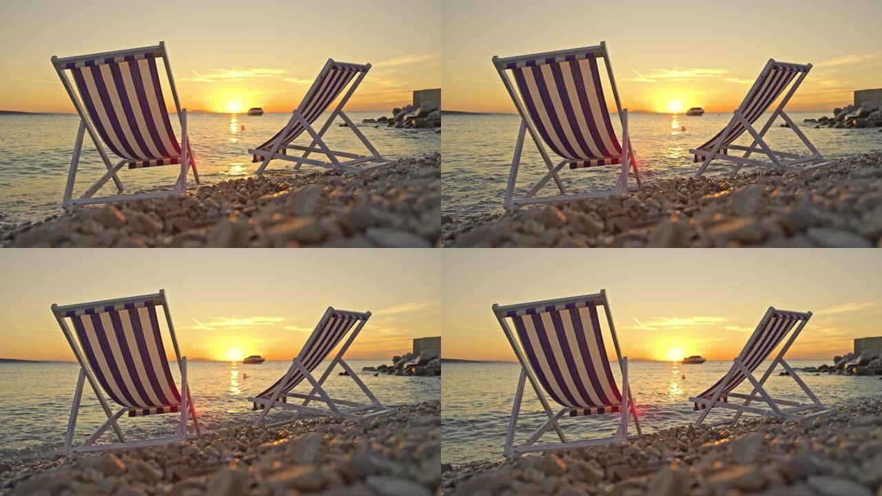 黄昏时海滩上的SLO MO两把沙滩椅