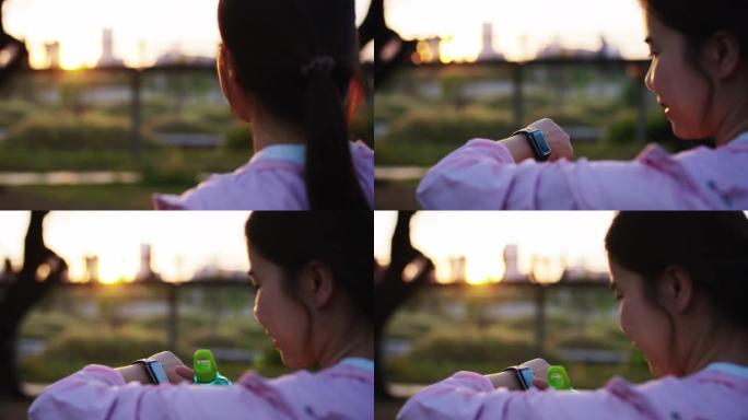 女人在公园运动时检查智能手表
