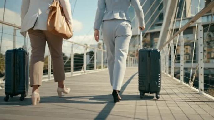 女人的腿带着旅行箱、行李行走，在度假、度假或公司旅行中行走。机场、航班预订和在城市桥上行走的商务人员