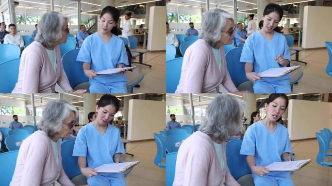 女护士帮高龄病人填表到医院就医