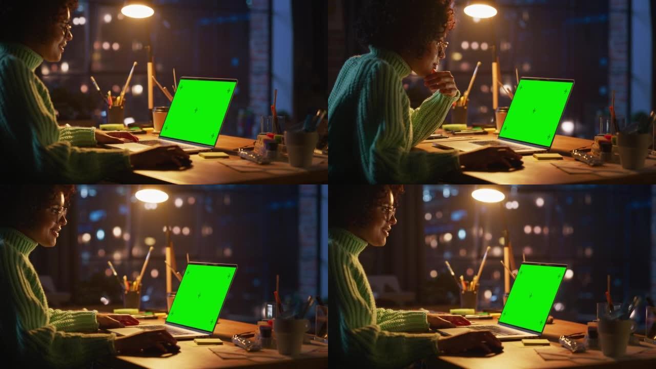 积极的女设计师在家在绿屏笔记本电脑上工作。女人在考虑新项目时使用电脑鼠标。自由职业者和千禧一代的概念