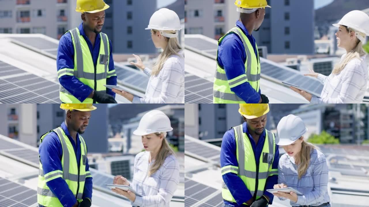 一个年轻的男人和女人在建筑物的屋顶上安装太阳能电池板时使用数字平板电脑。多元化的团队在从事可再生能源